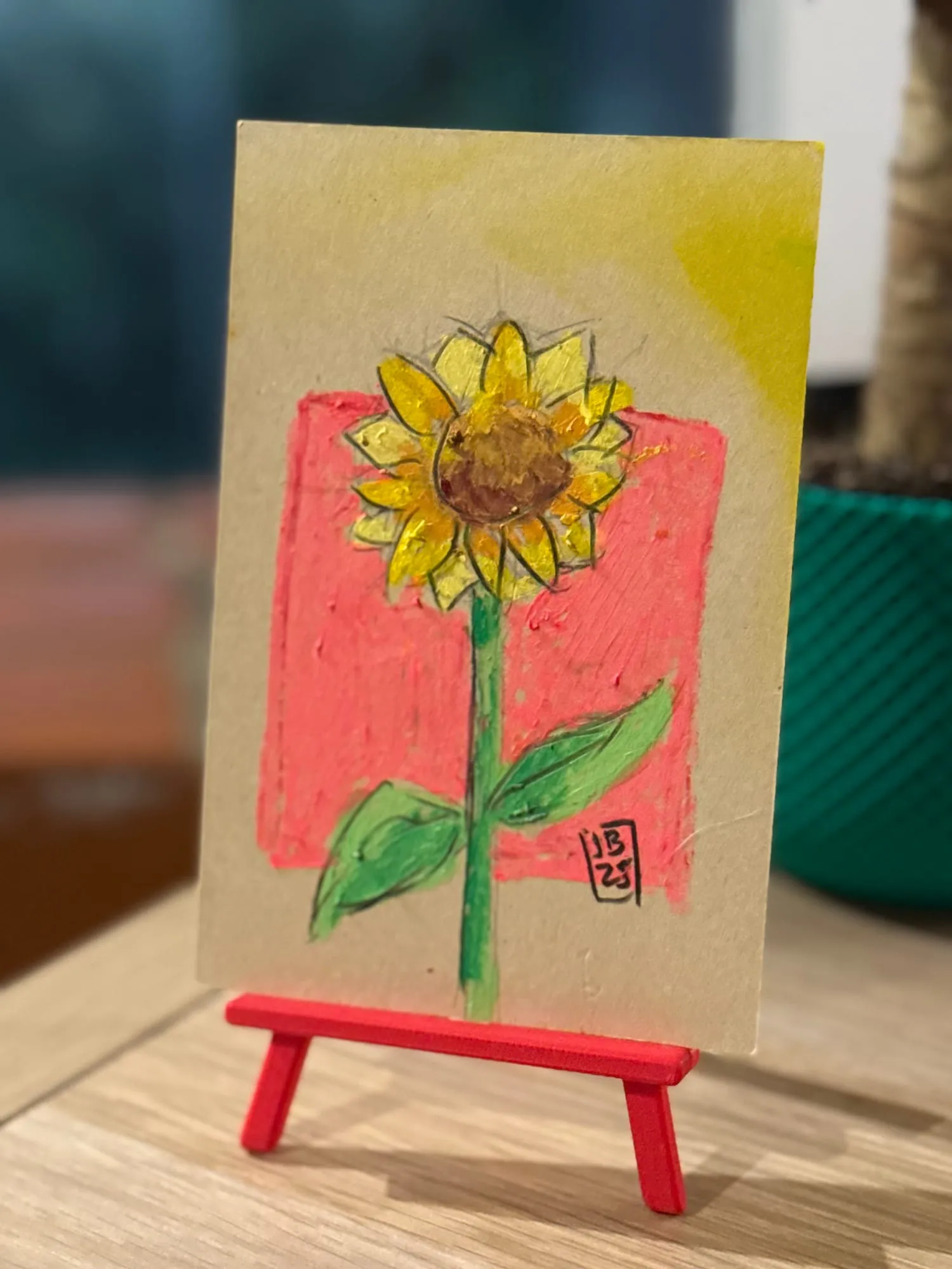 Girasol sobre rosado — la pieza en el caballete del estudio
