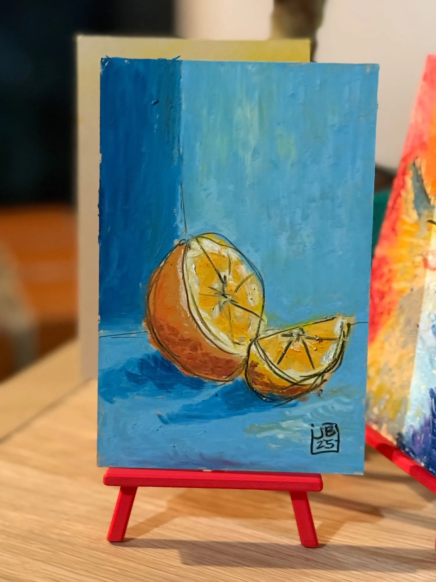 Naranja partida — la pieza en el caballete del estudio